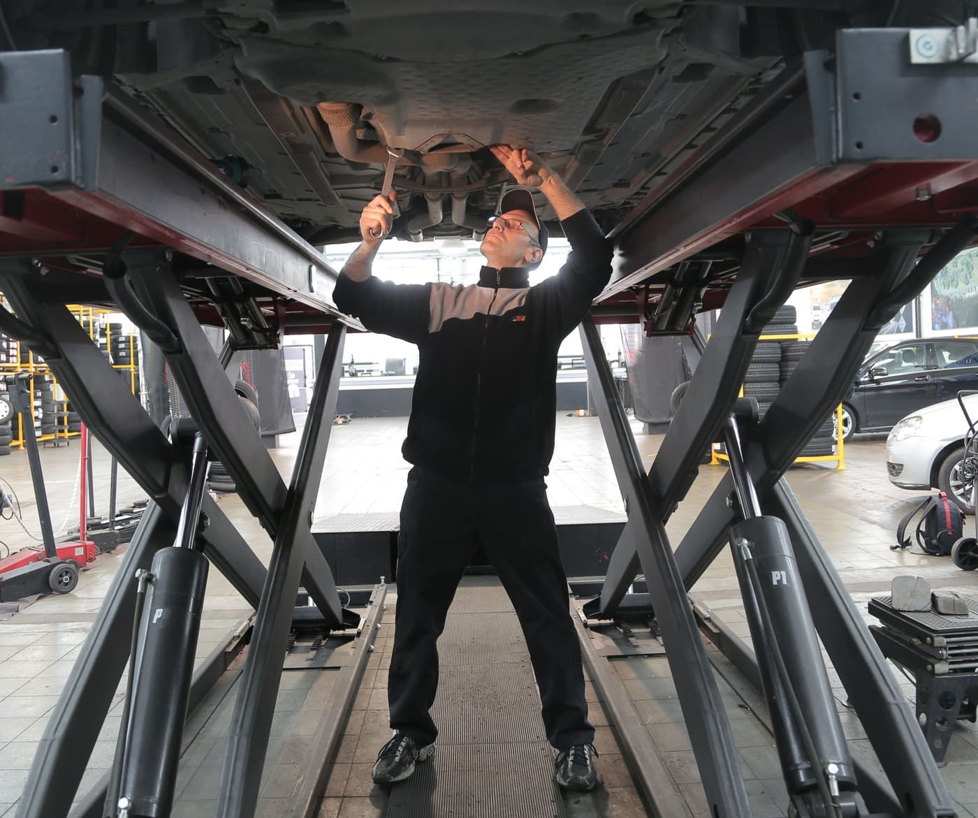 A mechanic inspecting and repairing a vehicle in a professional garage